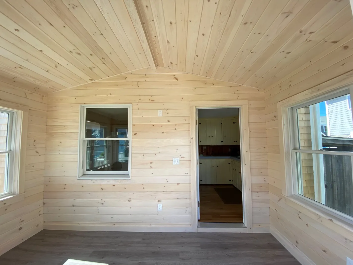 Finished pine-paneled interior room with new windows